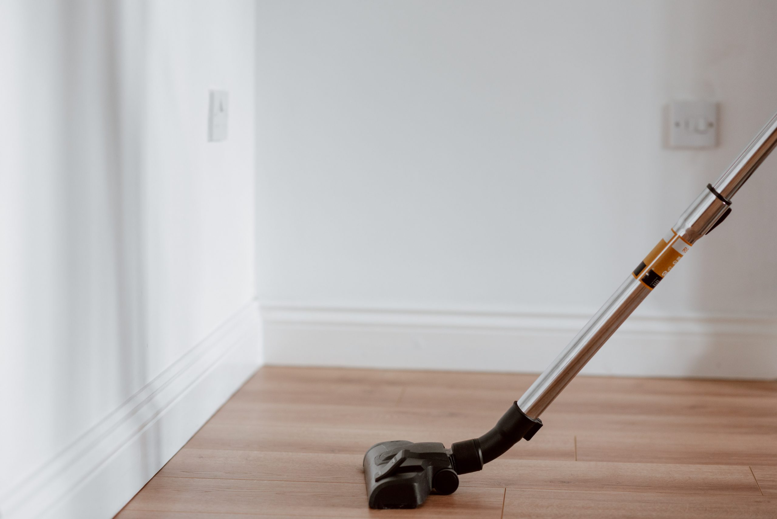 Modern vacuum cleaner washing floor in flat