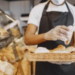 A person holding a tray of baked goods