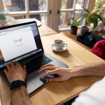 Person using macbook pro on brown wooden table