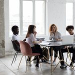 Focused diverse colleagues analyzing project together in office