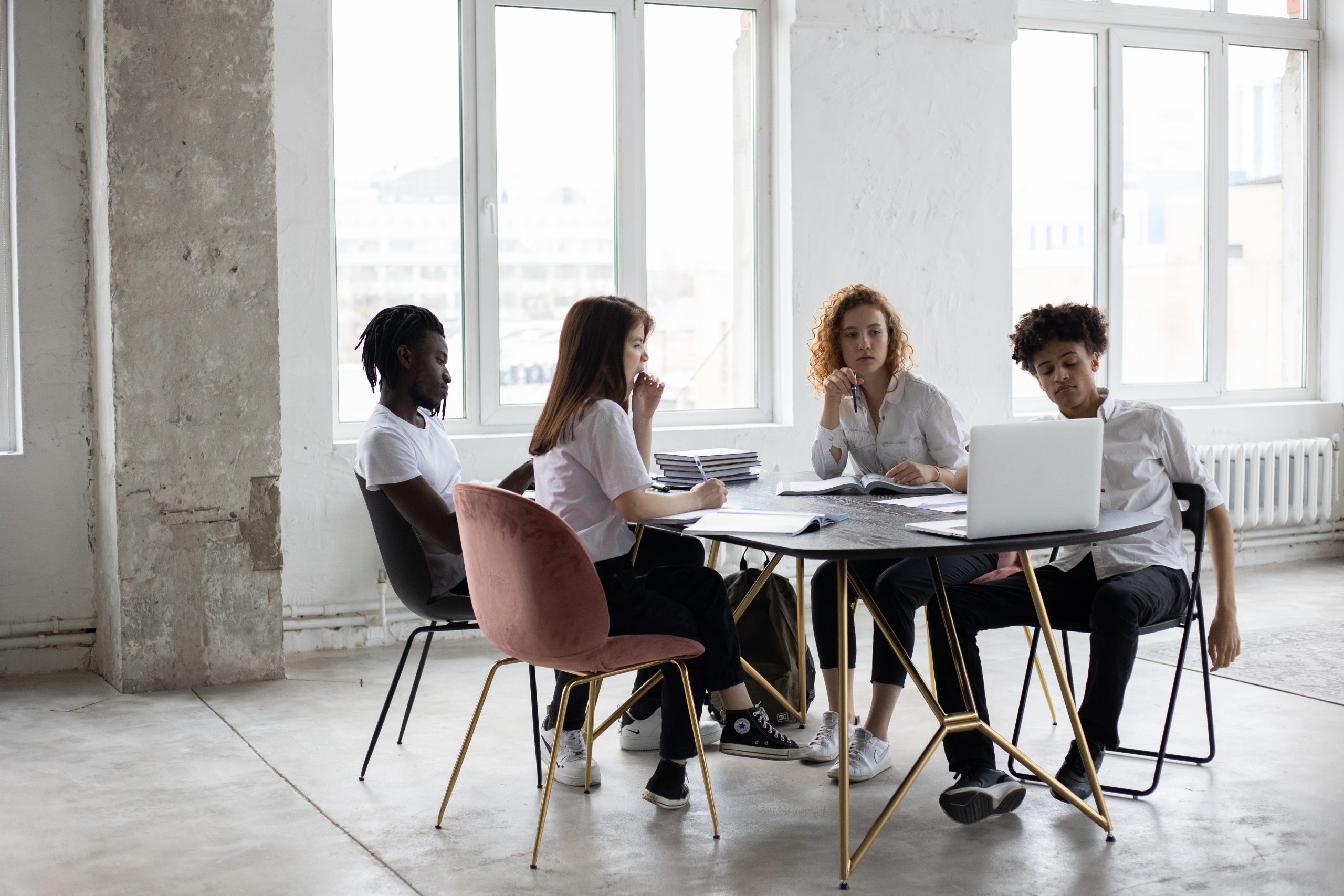 Focused diverse colleagues analyzing project together in office